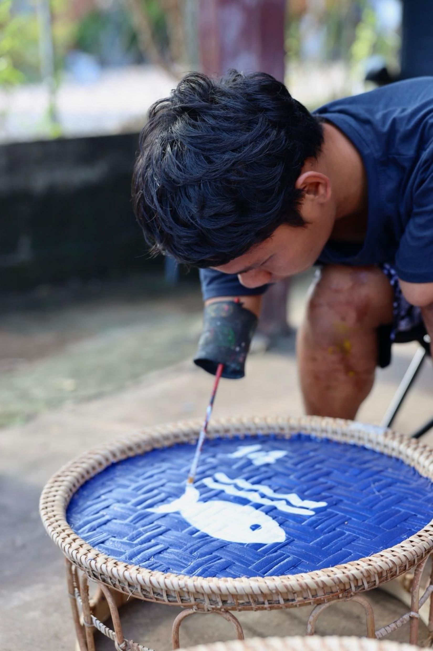 Artist (Seevanh) painting the SDG installation