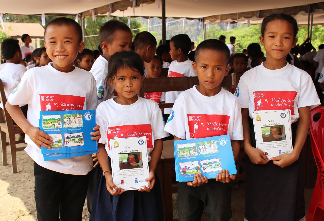 Kids are happy to receive the new UXO school curriculum textbooks.