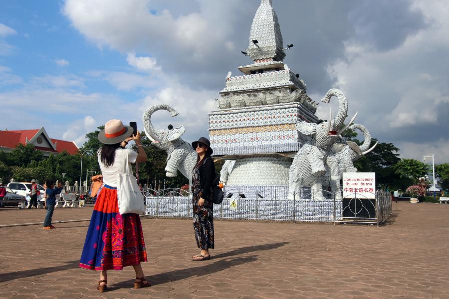 Tourists near the Lao-China friendship statue in Vientiane.